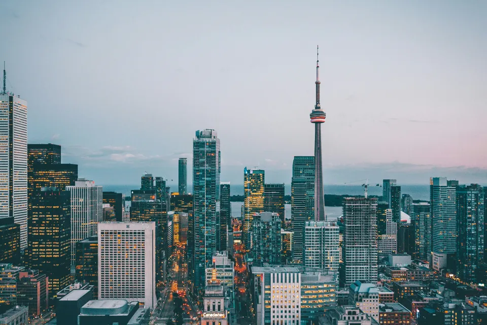 The Toronto skyline at dusk with the CN Tower and lit office towers.